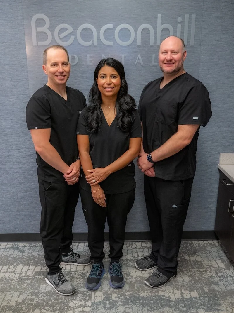 The friendly staff at beacon hill standing in front of the Beacon Hill sign. 